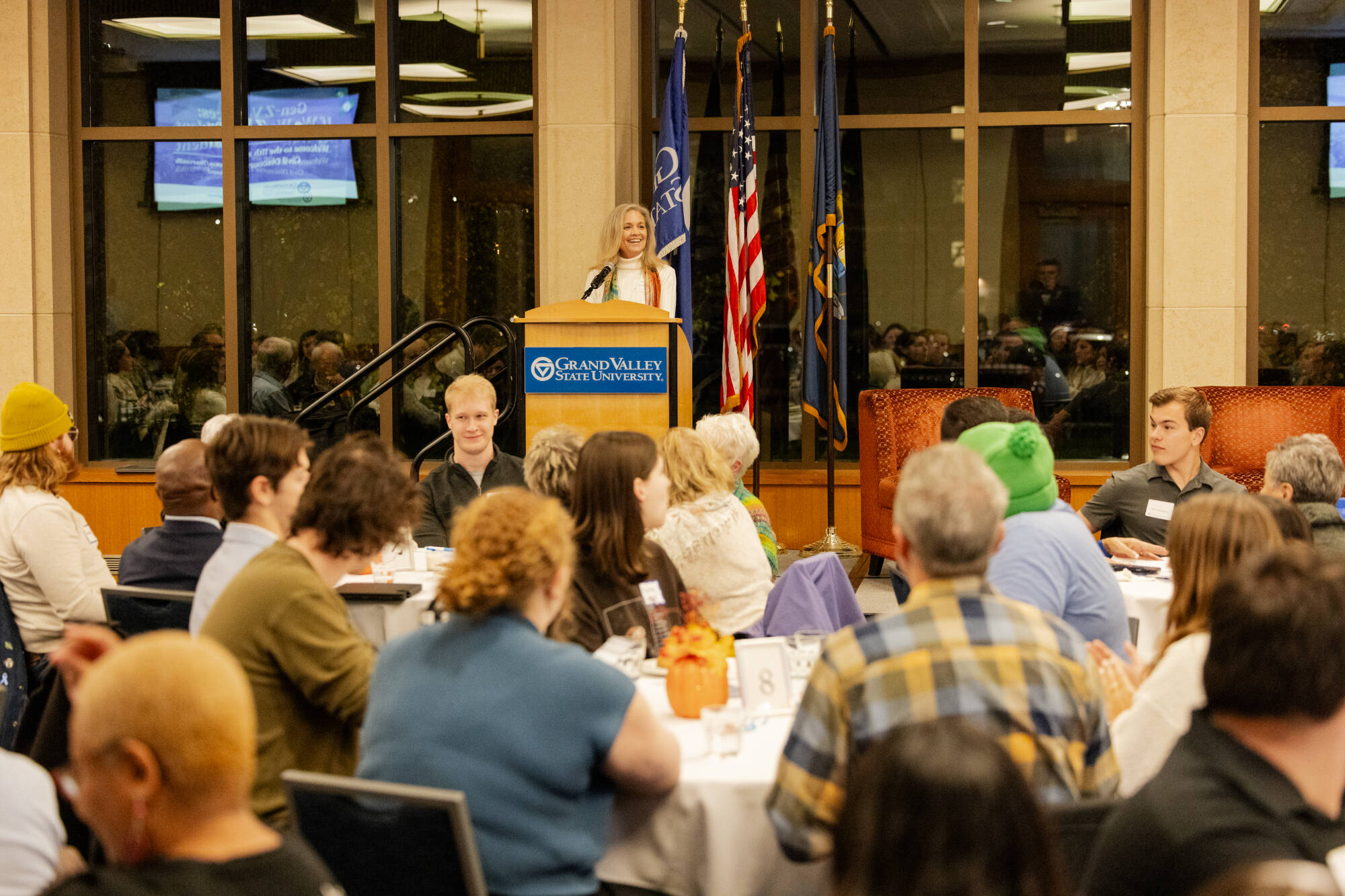 Lisa Perhamus at podium, people seated at tables in front